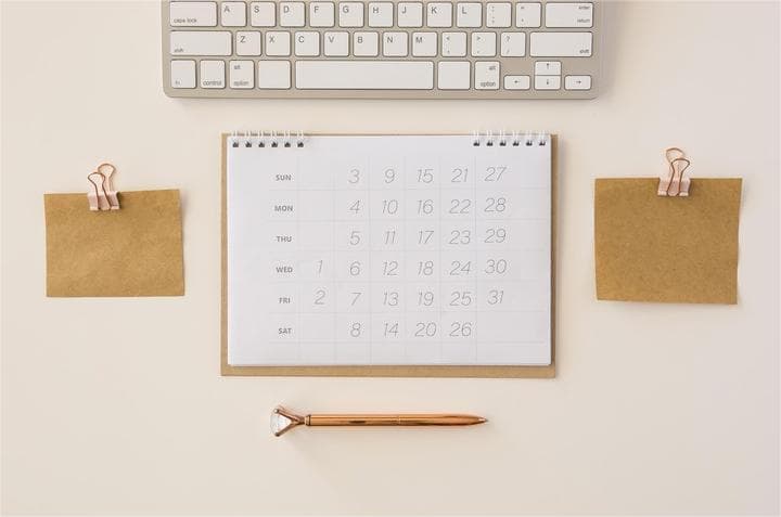 Minimalist desk setup with a calendar and pen