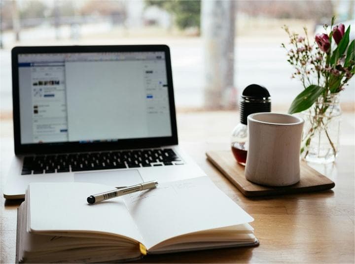 Minimalist desk with laptop and a pen